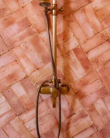 Zellige rose en chevrons et colonne de douche en laiton