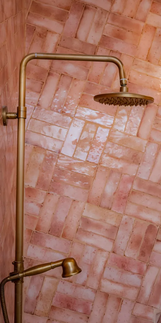 Zellige rose posé en chevrons et colonne de douche en laiton